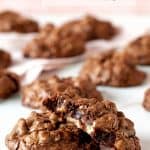 Whole and half chocolate cookies on white pink background with brown text overlay