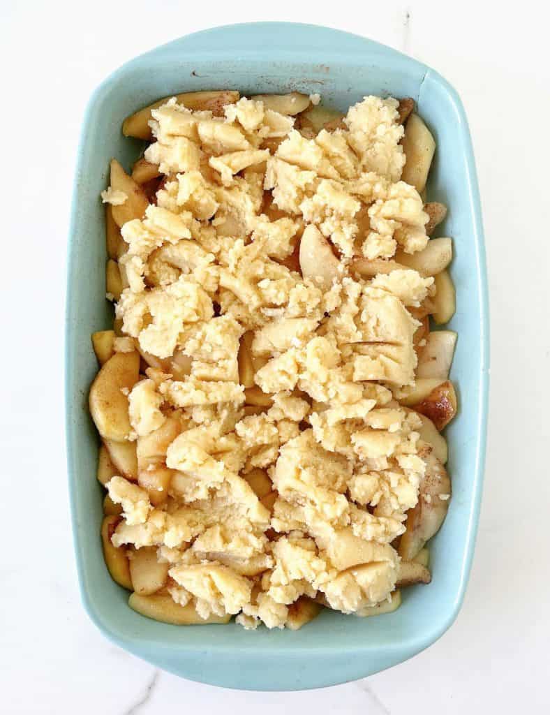 Overview of blue rectangular dish with unbaked fresh apple dump cake.