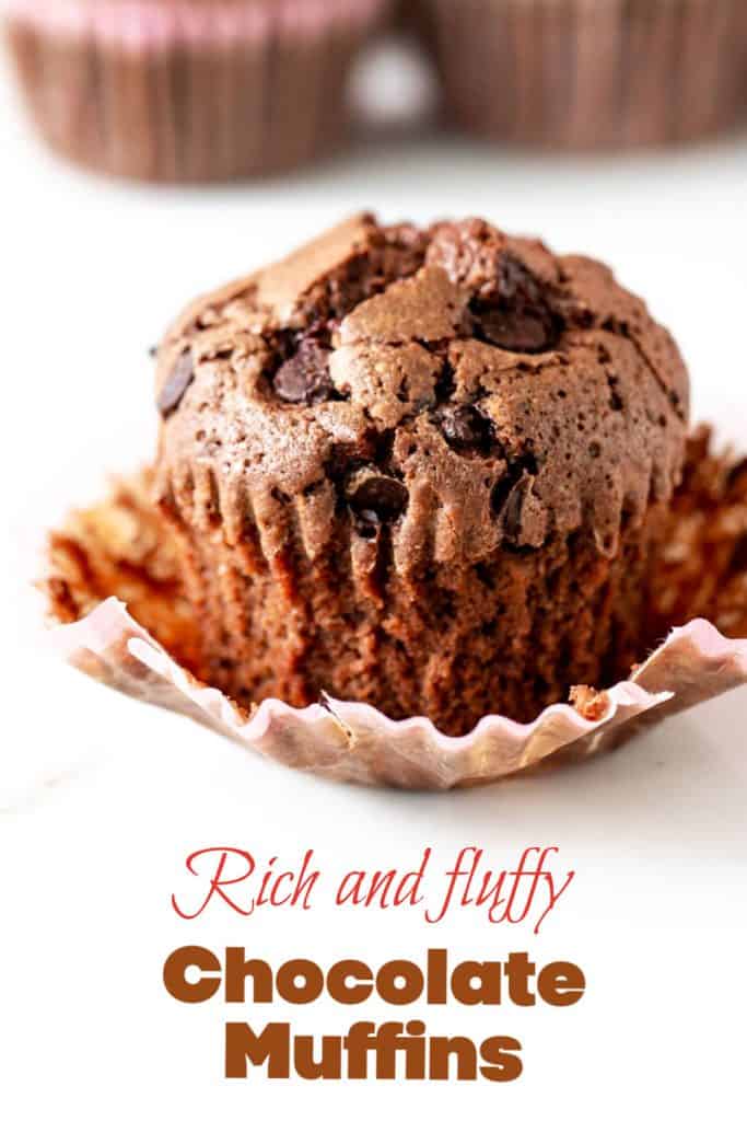 A chocolate muffin in an opened paper liner on white marble; pink brown text overlay