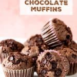 Several chocolate muffins on white marble with pink background; brown text overlay