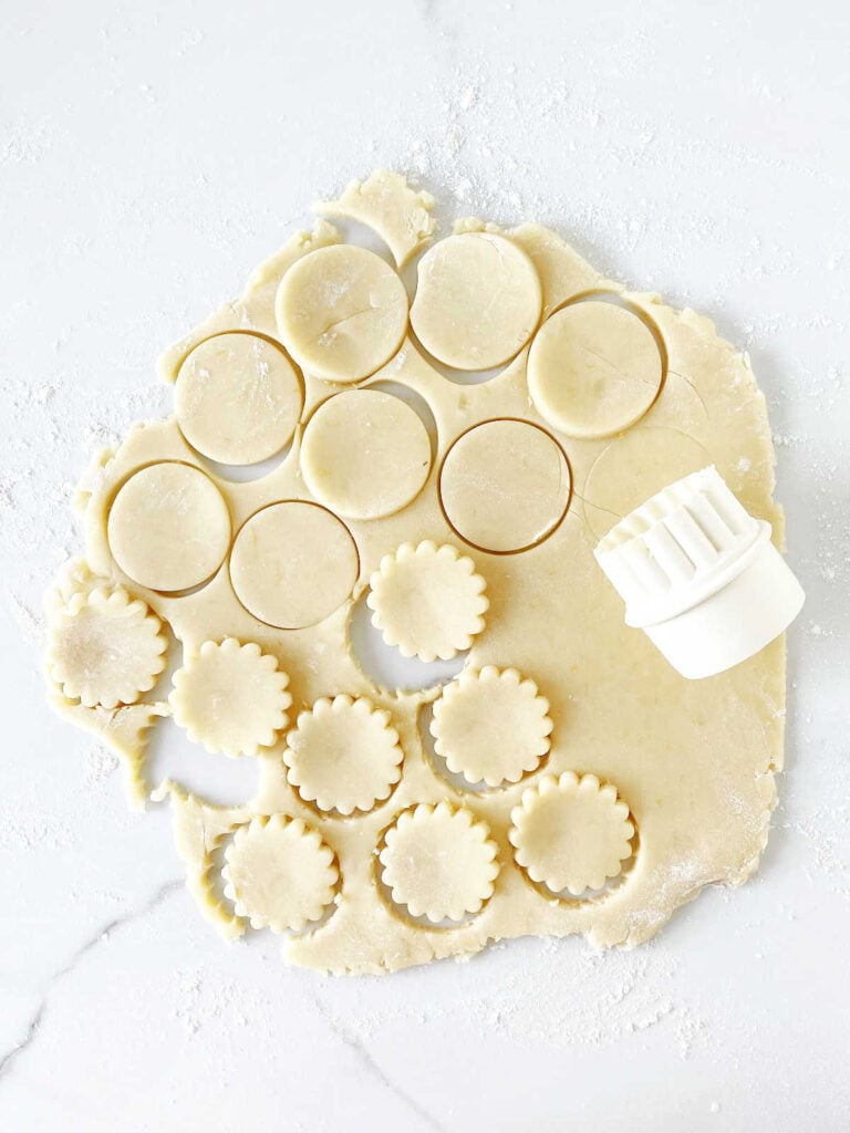 Rolled shortbread cookie dough on a white marbled surface.