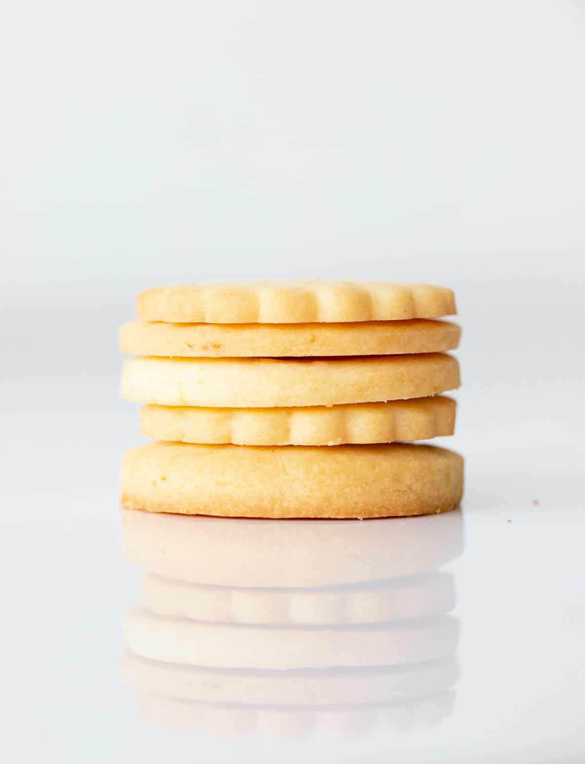 Several round cookies stacked with white marble surface and white background.