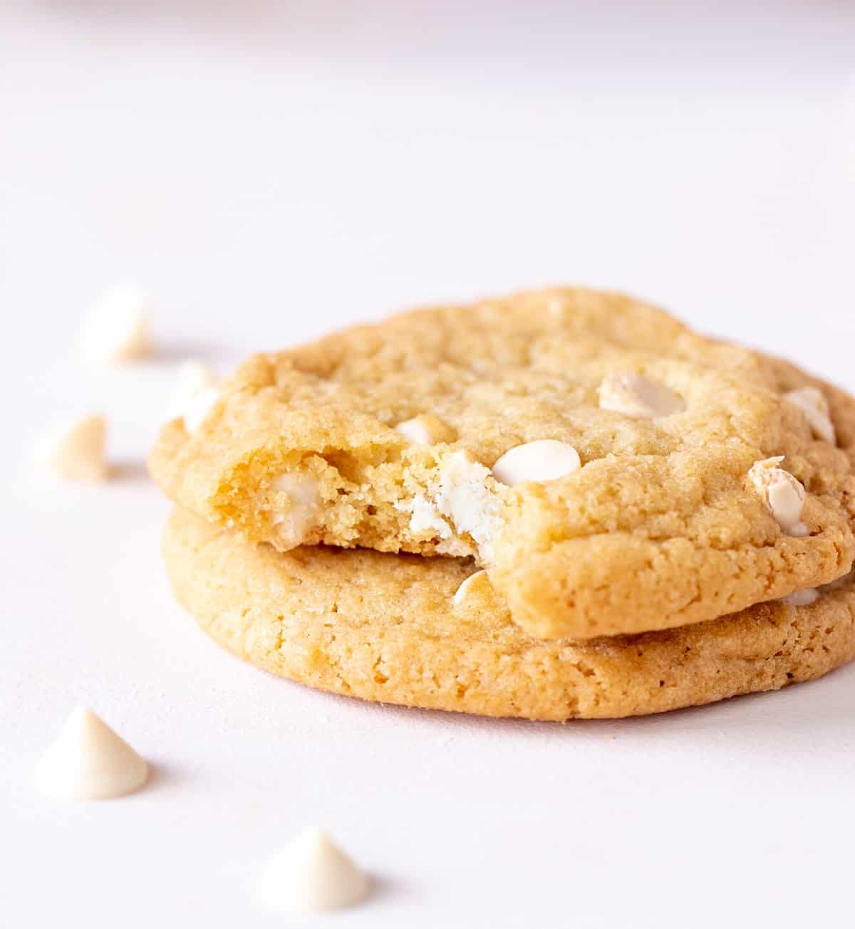 Bitten white chocolate cookie stacked on a white surface