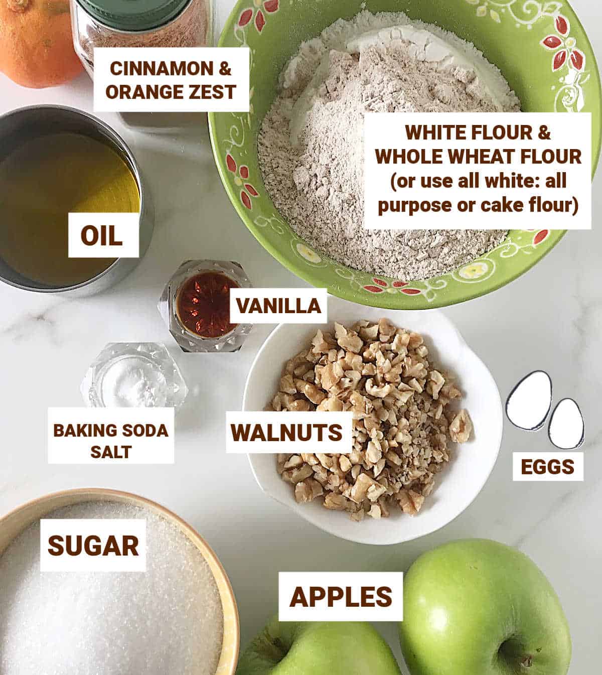 Apple walnut cake ingredients in bowls on white surface, including flours, sugar, oil, eggs, vanilla, cinnamon