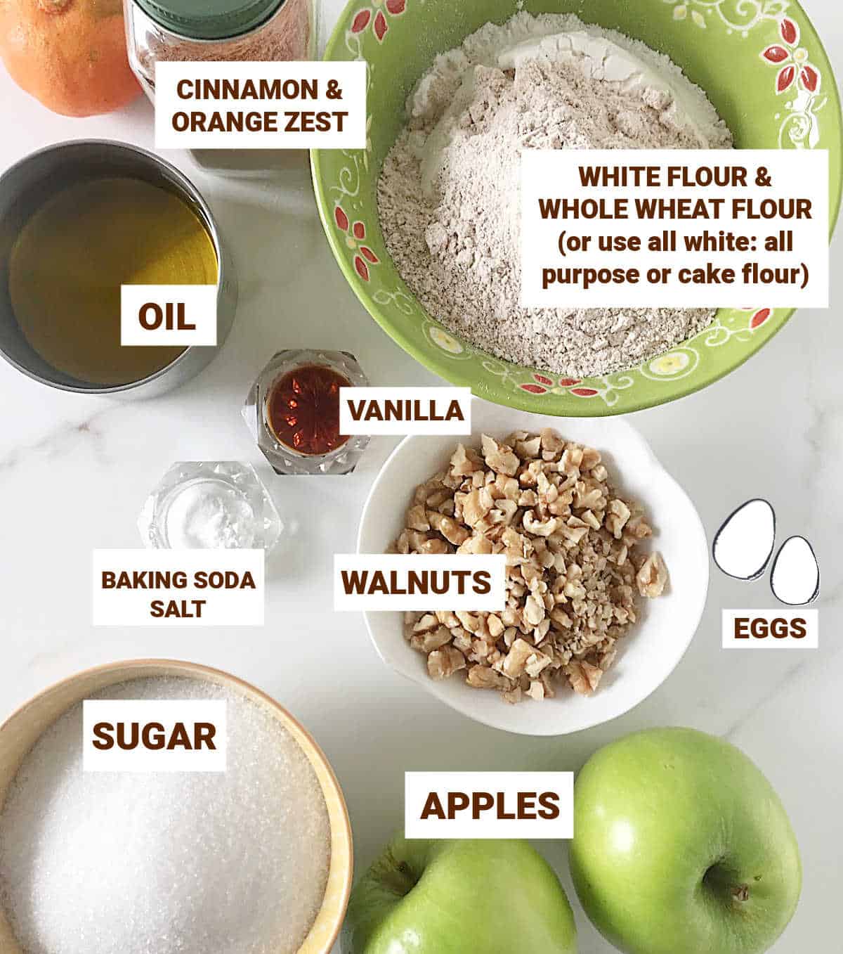 Ingredients for apple walnut cake in bowls on a white surface, including flours, sugar, oil, eggs, vanilla, cinnamon.