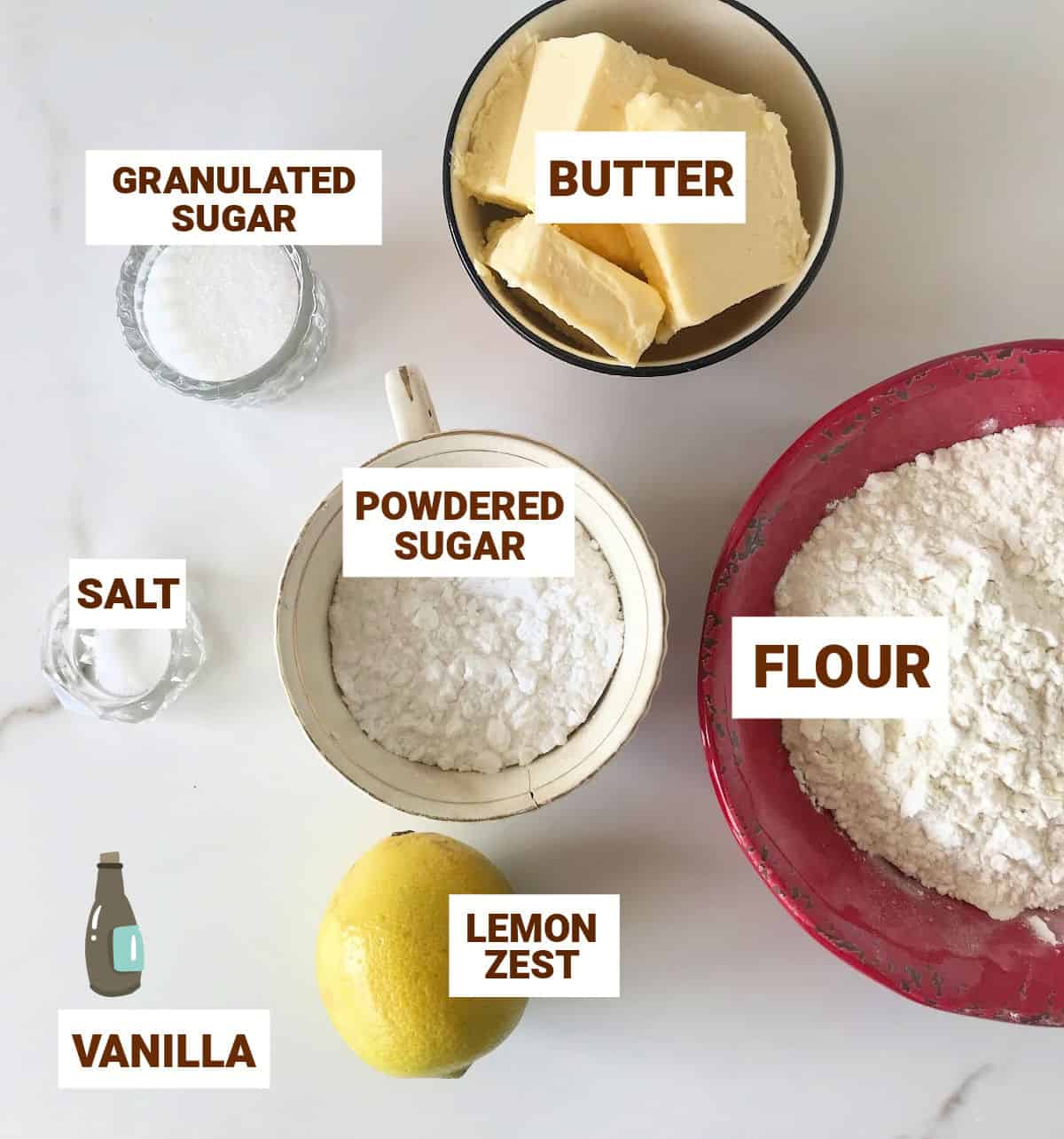 Bowls with lemon shortbread ingredients on marble surface including butter, sugars, vanilla. Text overlay.