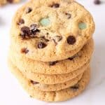 Close up of stack of chocolate chip mint cookies on white surface, brown text overlay