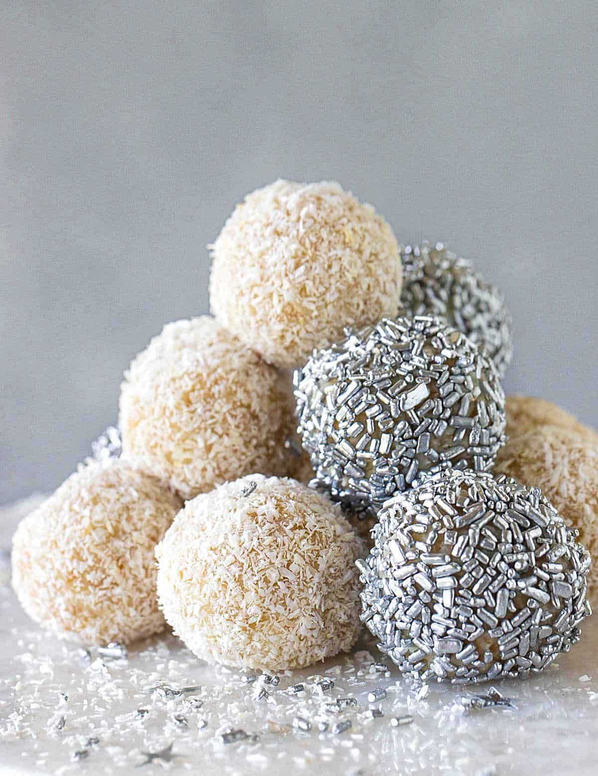 Stack of white and silver truffles on marble surface, grey background