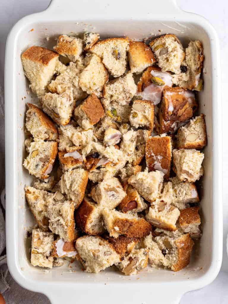 Cubed panettone bread in a rectangular white baking dish. Top view.