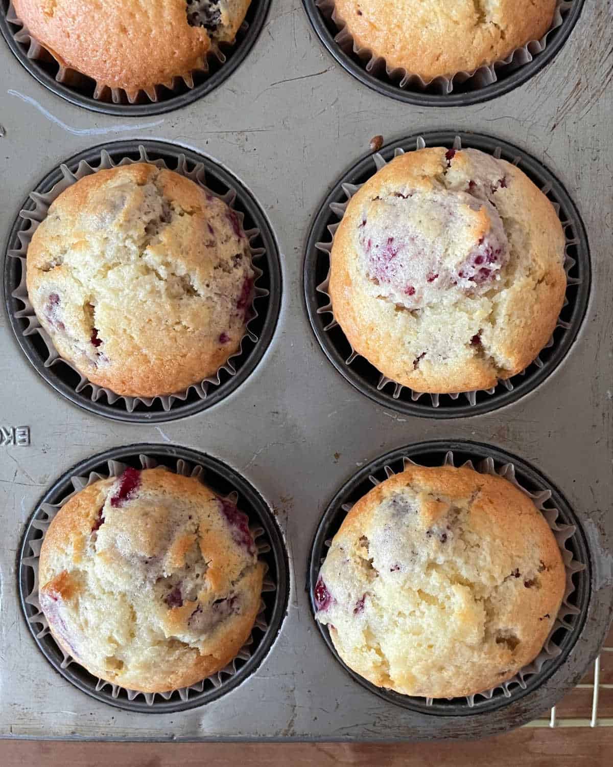 Top view of baked raspberry muffins in a metal pan.