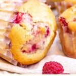 Red, white and brown text overlay on whole raspberry muffins.