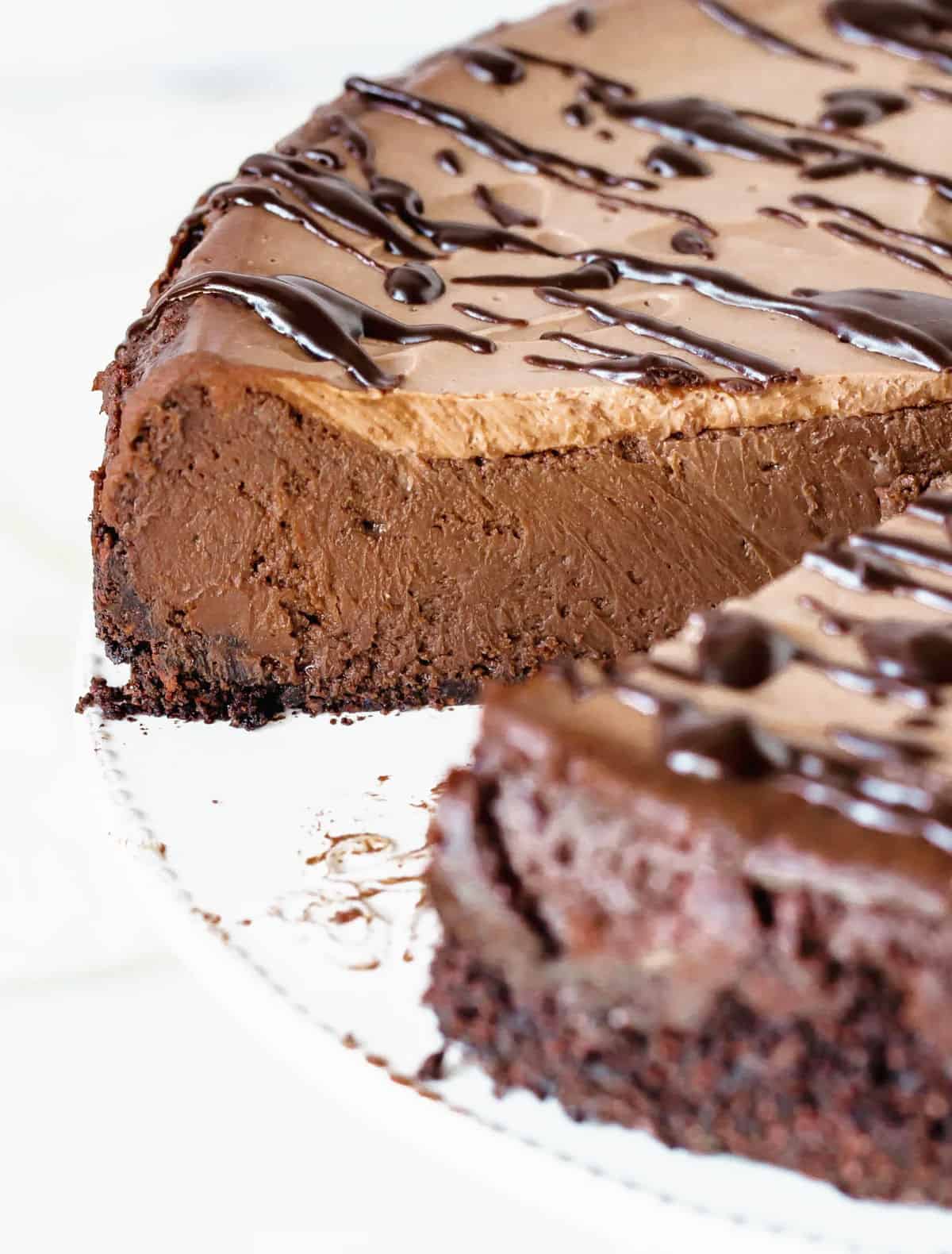 Close up of inside of chocolate cheesecake on white plate.