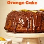 Cake stand with chocolate glazed bundt cake, beige background, orange brown text overlay.