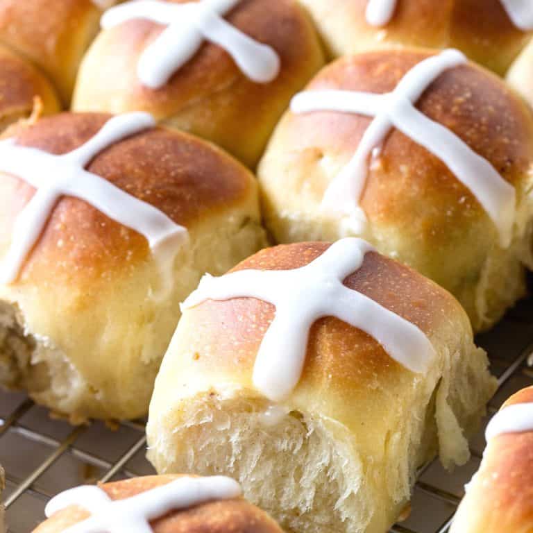 Close up of small sweet buns with white crosses on top.