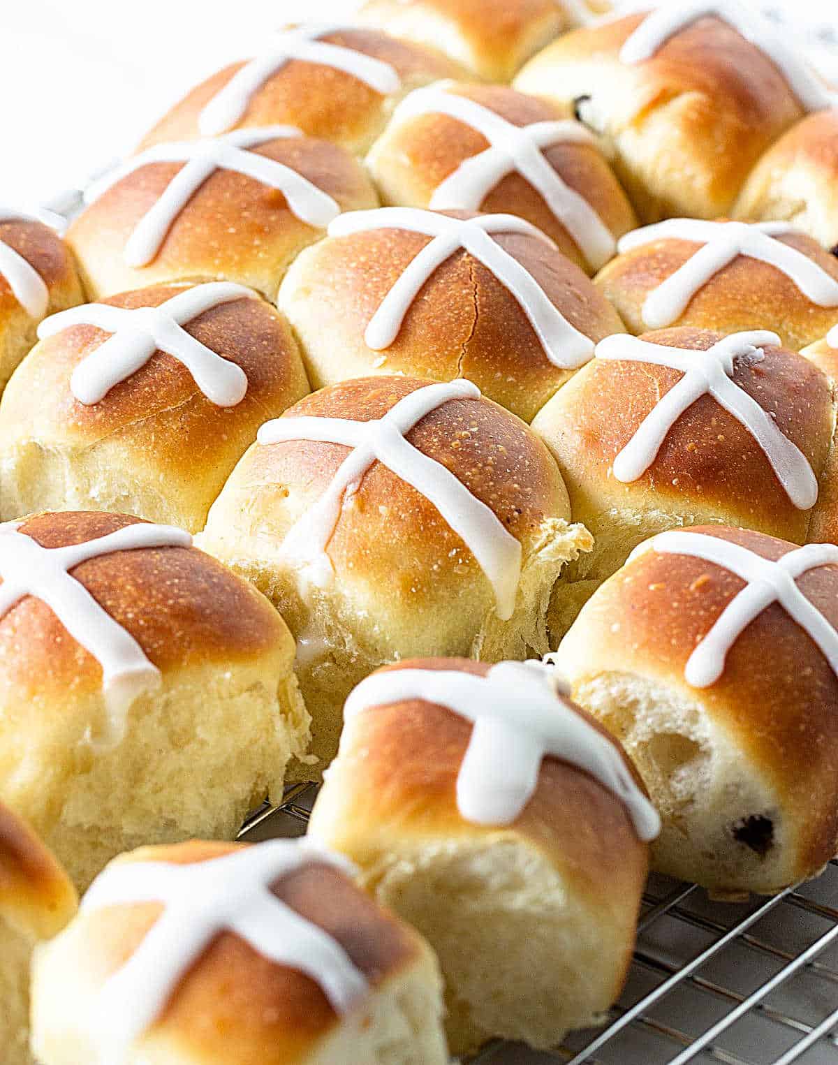Rows of small buns with white cross on top.