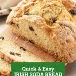 Loaf of Irish soda bread with raisins on wooden board, green text overlay.