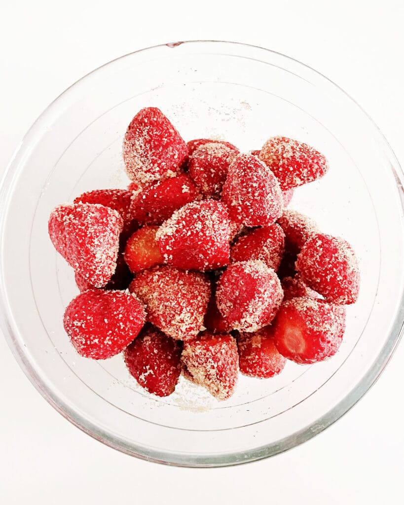 Brown sugar and strawberries in a glass bowl.