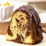 Slice of glazed marbled bundt cake with brown text overlay.