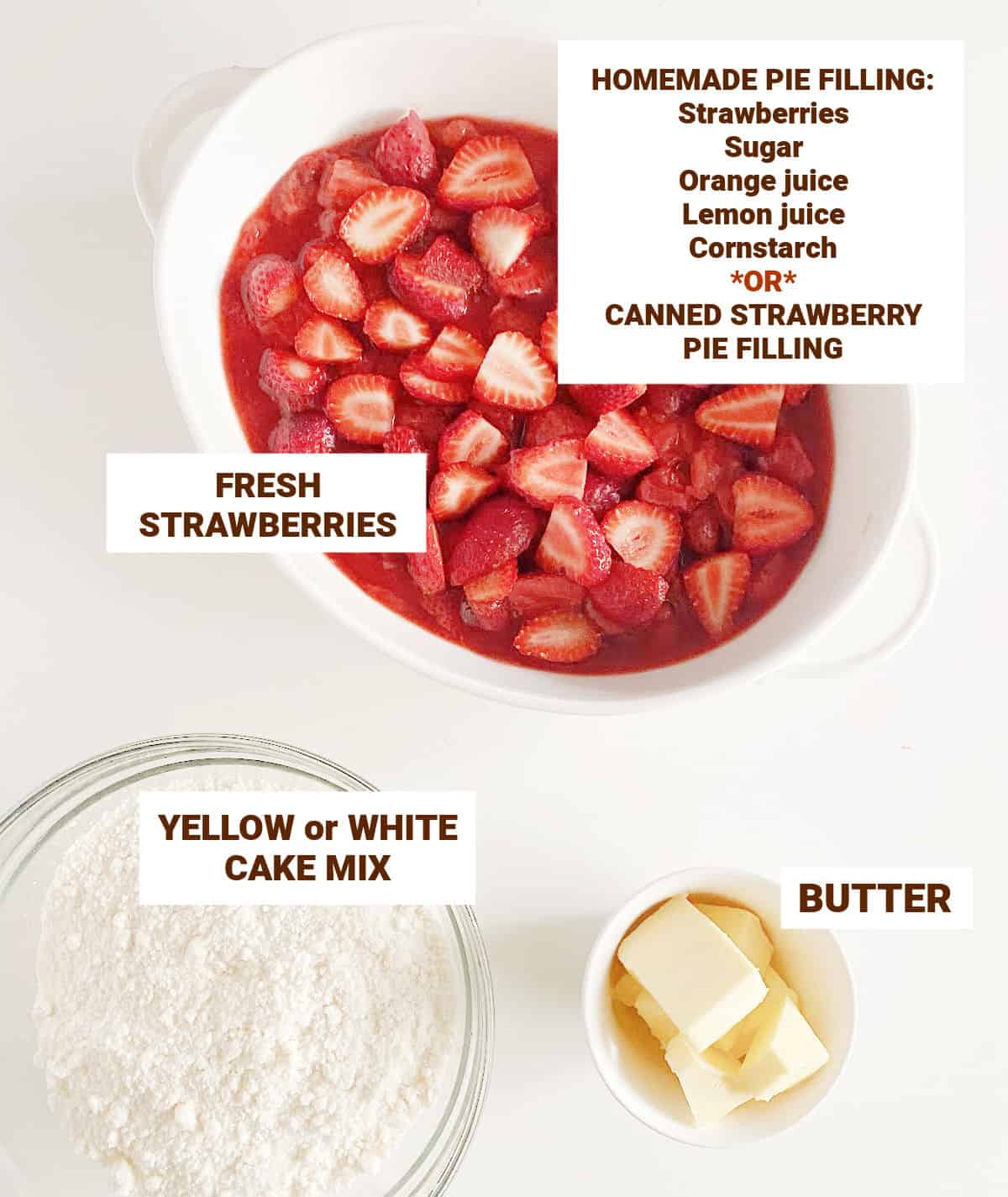 Strawberries in white dish, bowl with cake mix, bowl with butter on a white table.