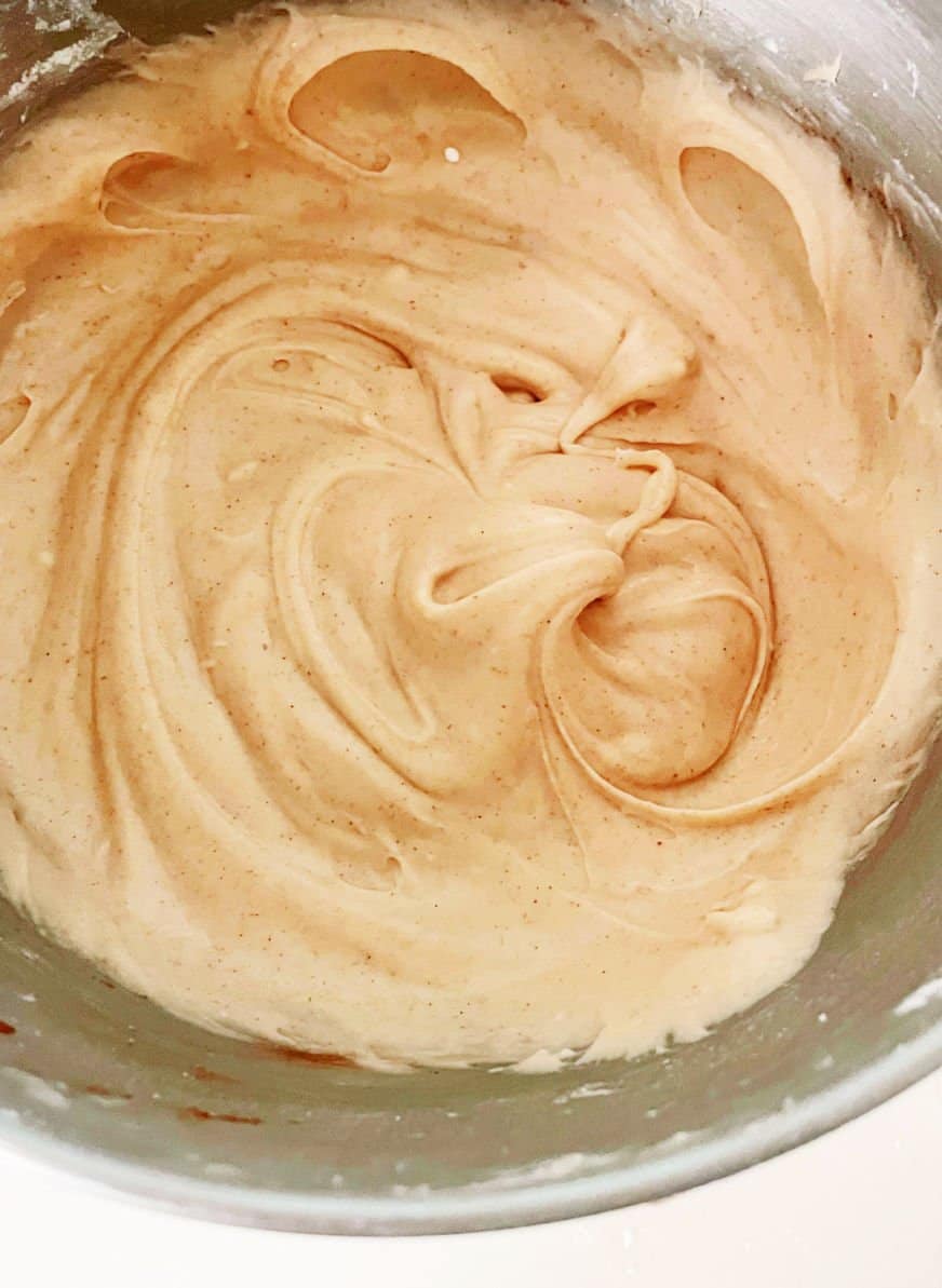 Close up of cinnamon cream cheese frosting in metal bowl.