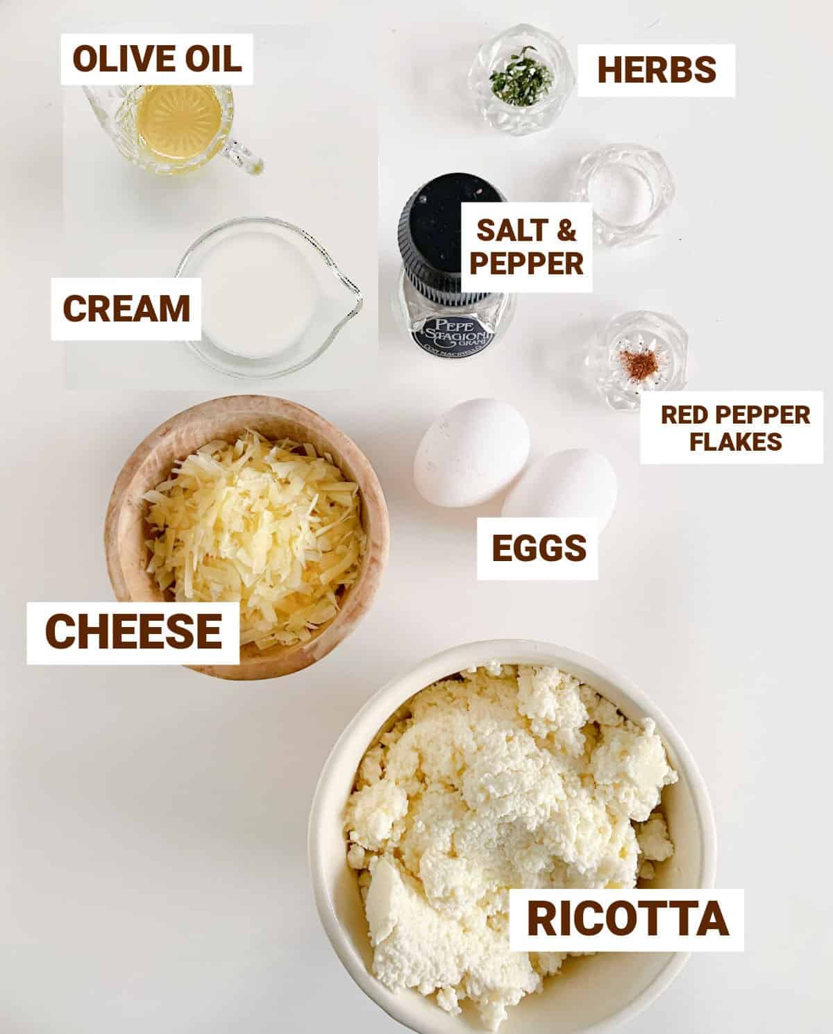 White surface with bowls containing ingredients for baked ricotta including cheese, oil, eggs, flavorings, cream, herbs.