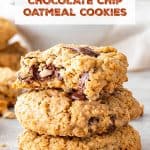 Grey surface with stack of chocolate chip oatmeal cookies, one bitten. Brown and white text overlay.