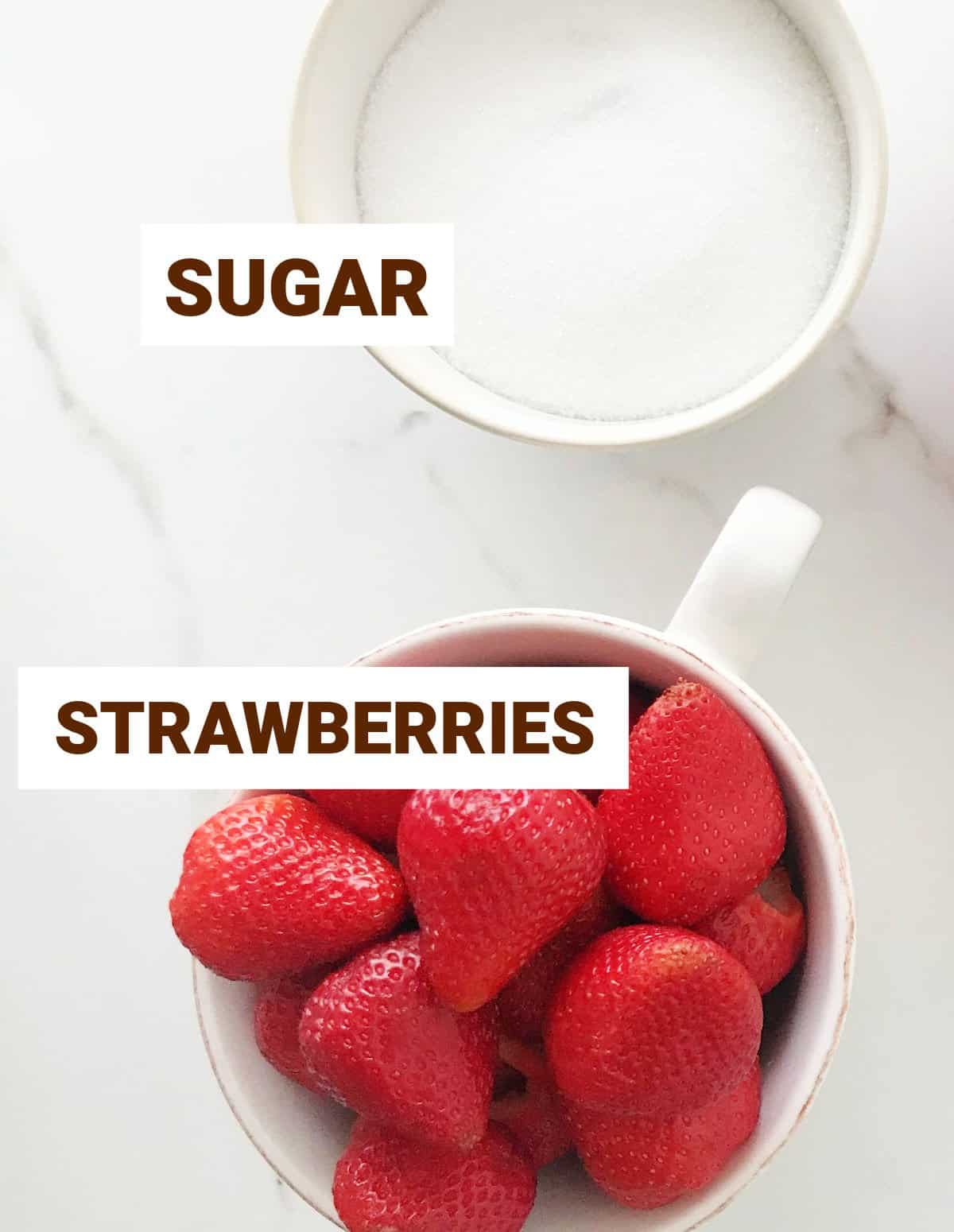 White marble with bowls containing sugar and fresh strawberries. Overview image.