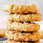 Brown and white text overlay on a stack of oatmeal cookies. Gary background.