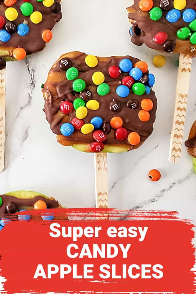 Close up of chocolate and candy covered apple slices on a stick. Red text overlay.