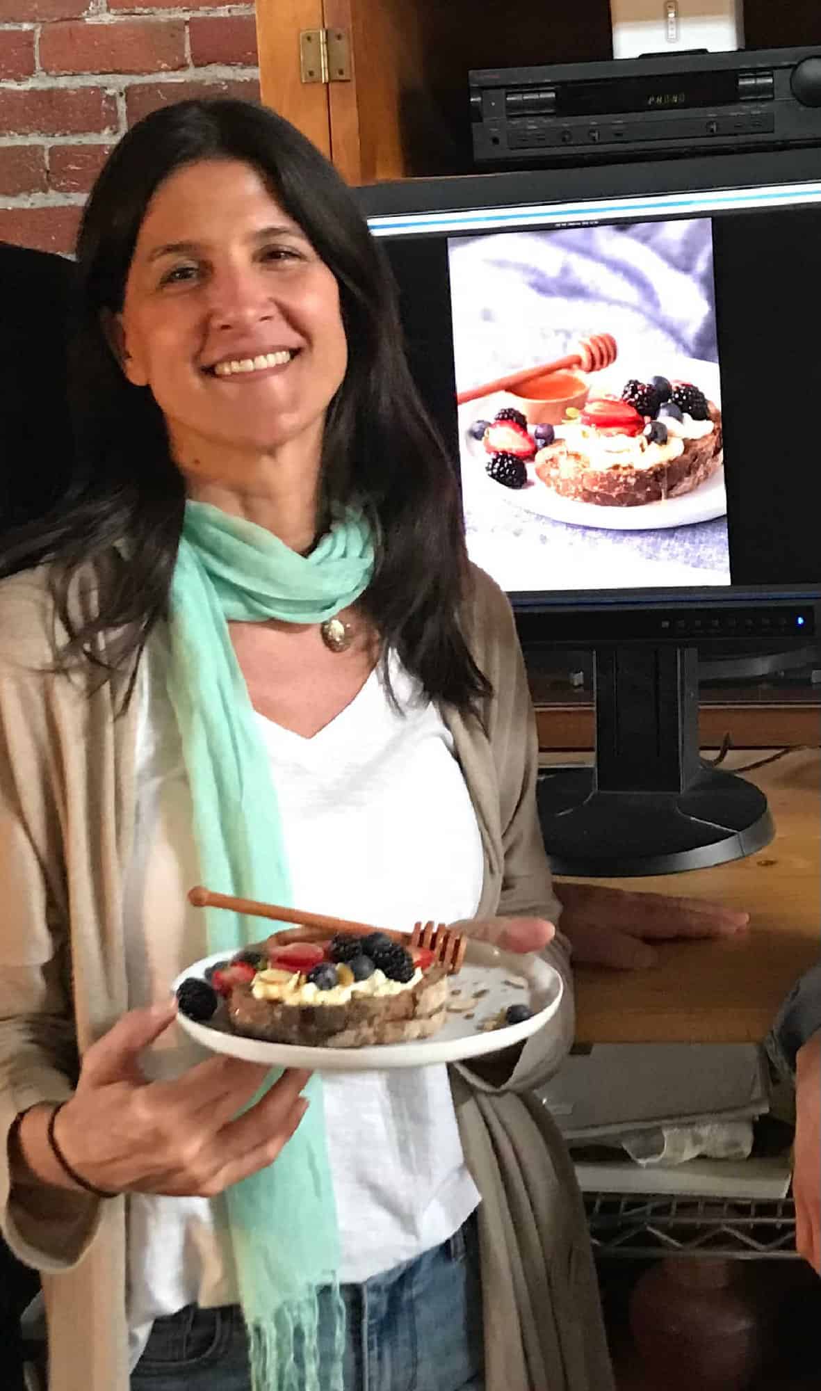Dark haired person holding plate with food and image of said plate in background.
