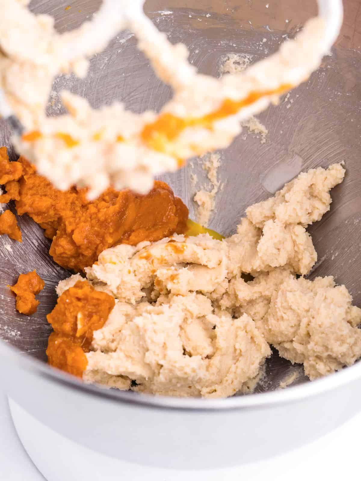 Metal mixer bowl with pumpkin and butter for cookie dough.