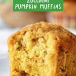 Close up of bitten pumpkin zucchini muffin on a white plate with green text overlay.