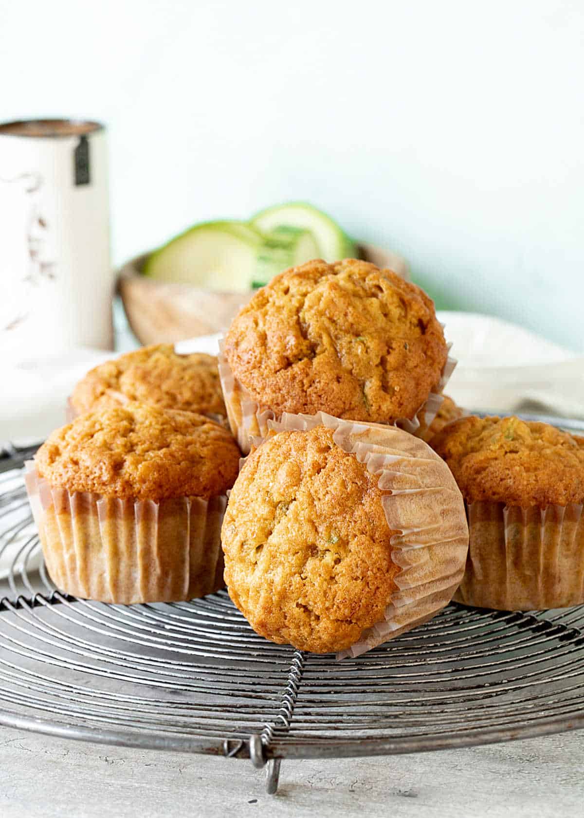 Several zucchini pumpkin muffins in paper liners on a wire rack. 