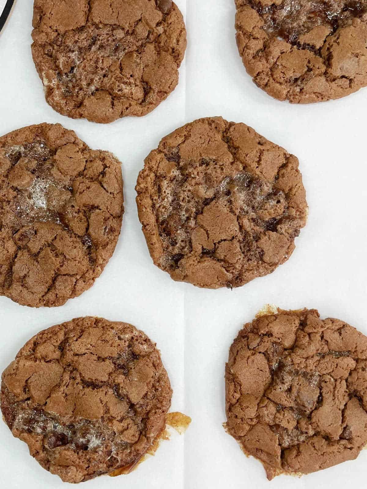Baked chocolate cookies on a white piece of paper.