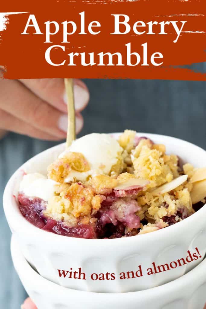 Brown and white text overlay on image of white bowls with apple berry crisp and teal background.