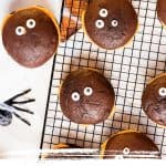 Top view of halloween whoopie pies on a black wire rack with black text overlay and thematic graphics.