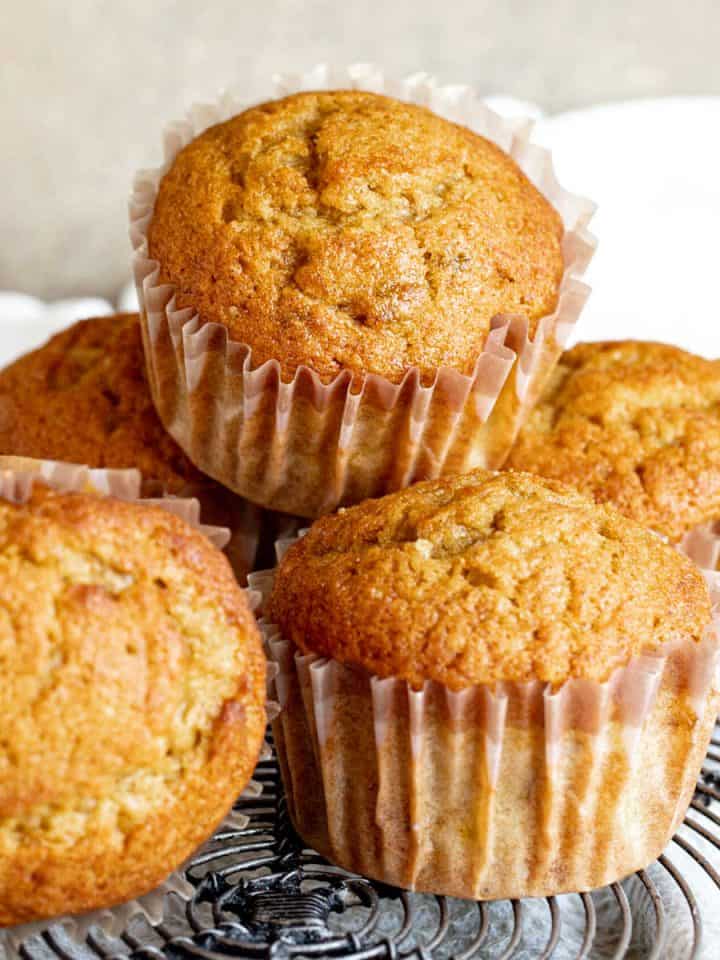 Several banana pumpkin muffins on a wire rack with a beige and white background.