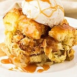 Serving of apple caramel bread pudding with cream. Green, brown and white text overlay.
