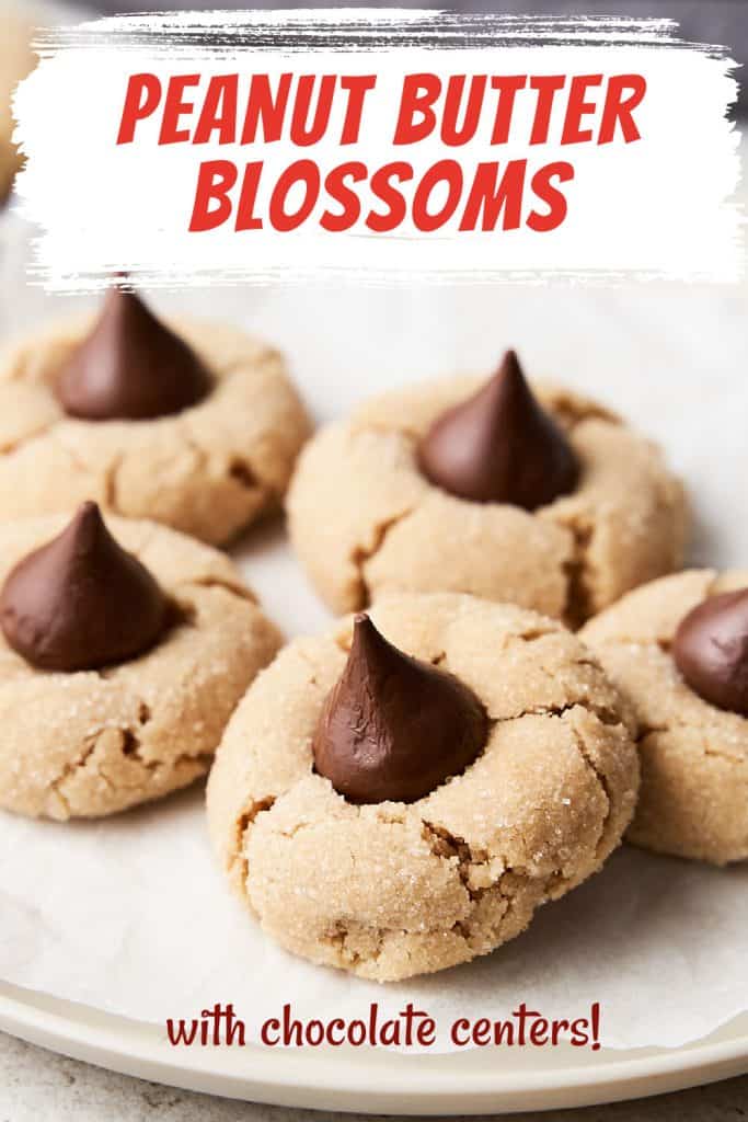 Red, white, and brown text overlay on image of several peanut butter blossom cookies on a plate.