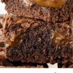 White, pink and brown text overlay on close up of stack of gooey dulce de leche brownies.
