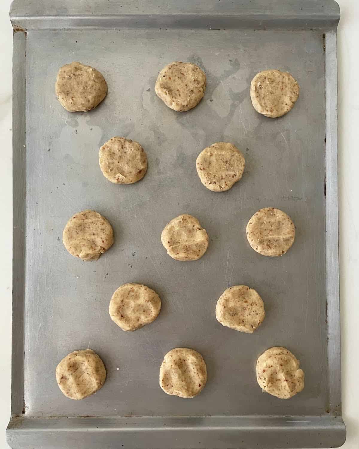 Metal baking sheet with pecan cookies before baking. Top view.