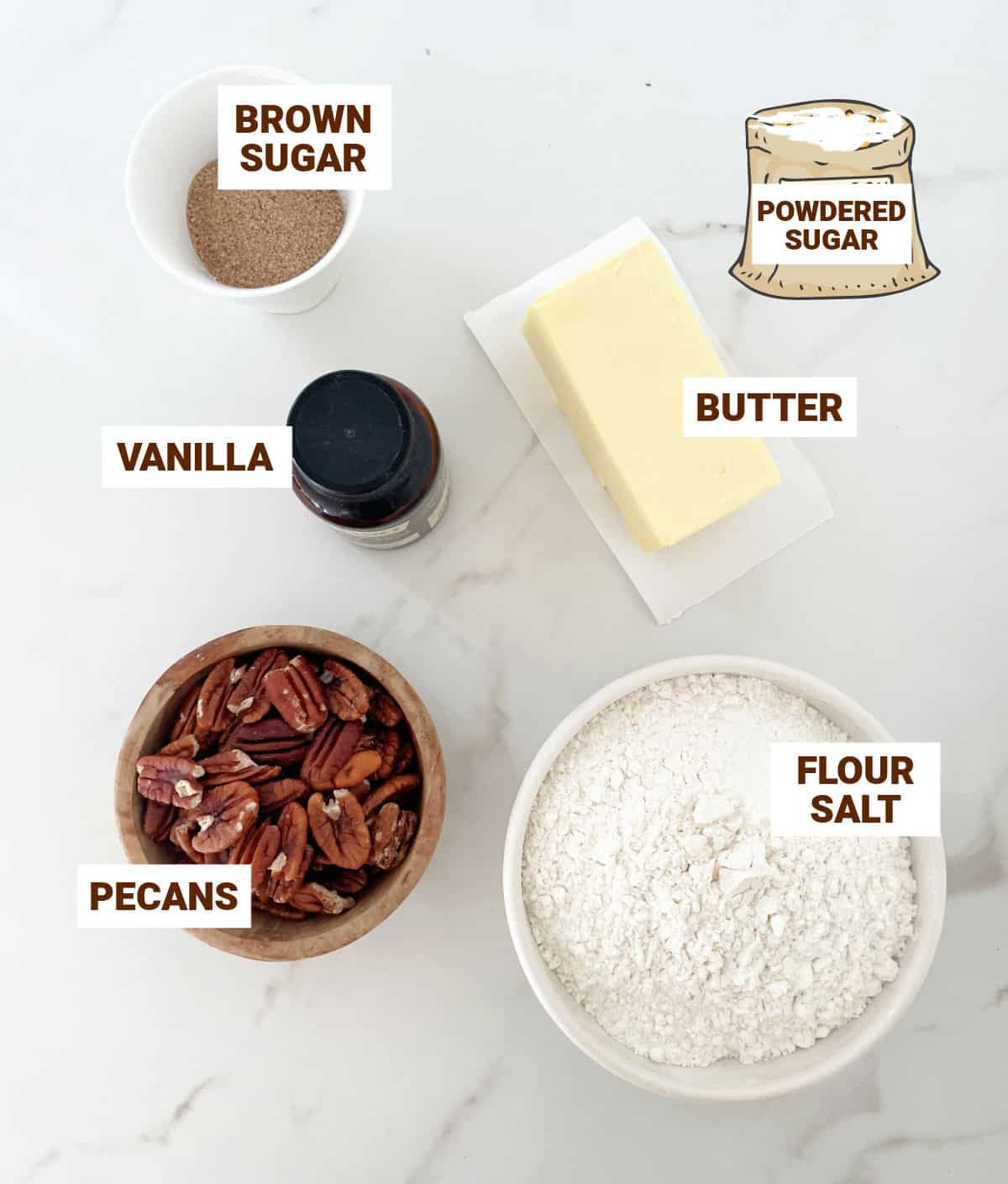 Bowls on a white marble surface with ingredients for pecan cookies including butter, flour, brown sugar, vanilla, salt.