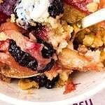 Black and white text on close up blackberry apple crumble serving.