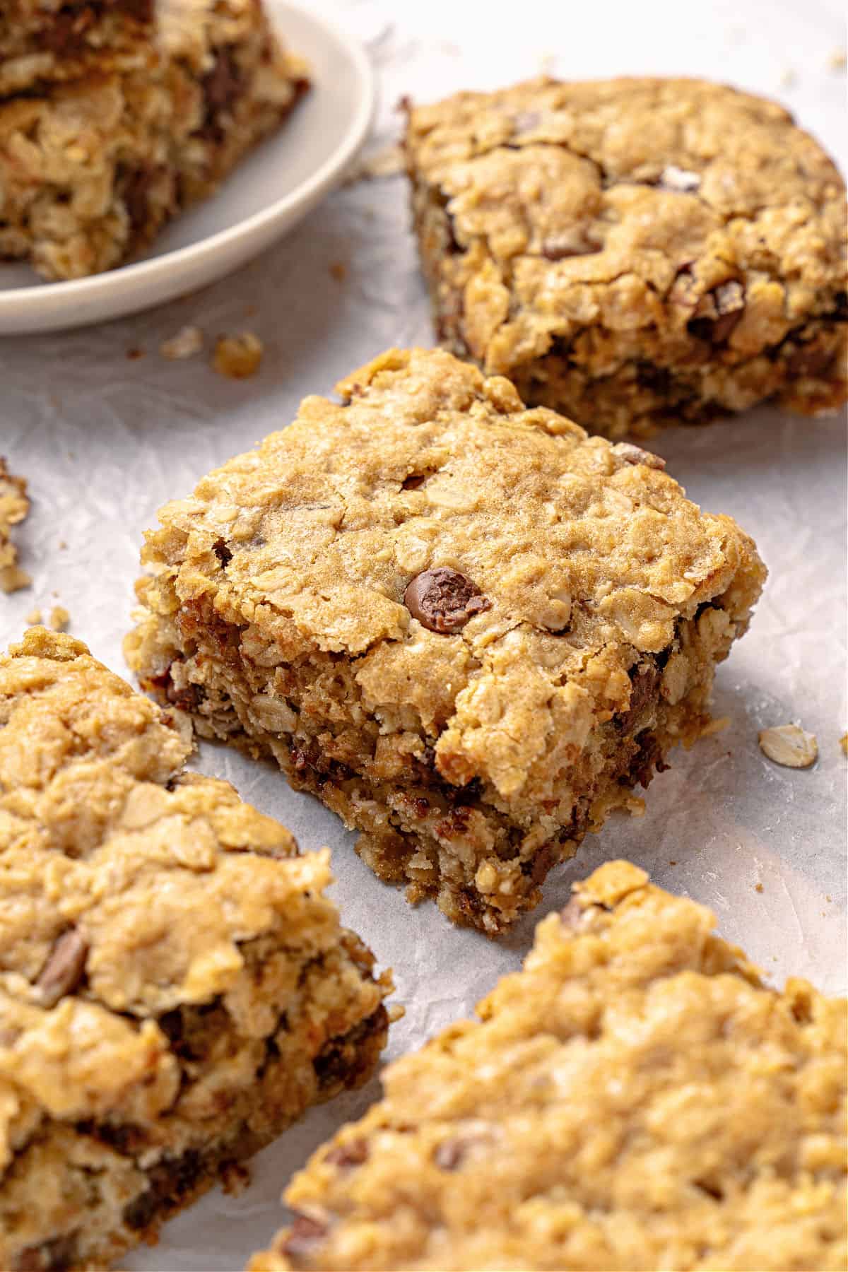 Squares with oats and chocolate chip close up on parchment paper.