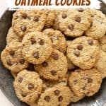 Brown and white text overlay on image of chocolate chip oatmeal cookie pile on a tin plate.