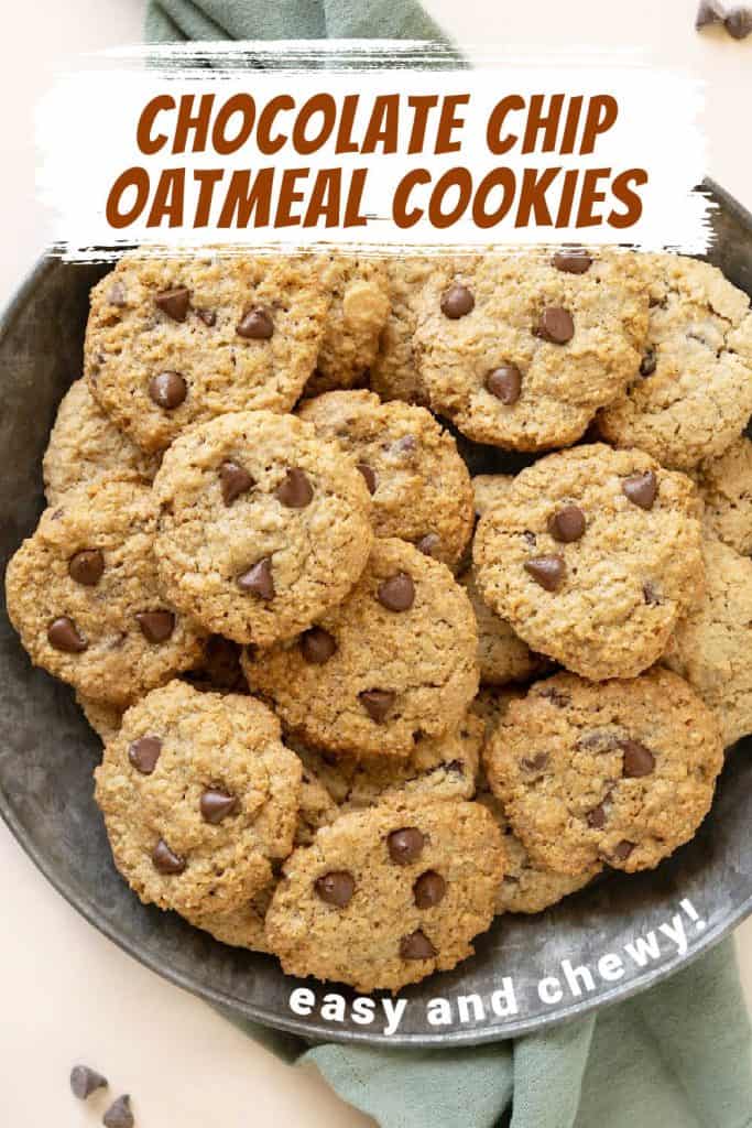 Brown and white text overlay on image of chocolate chip oatmeal cookie pile on a tin plate.