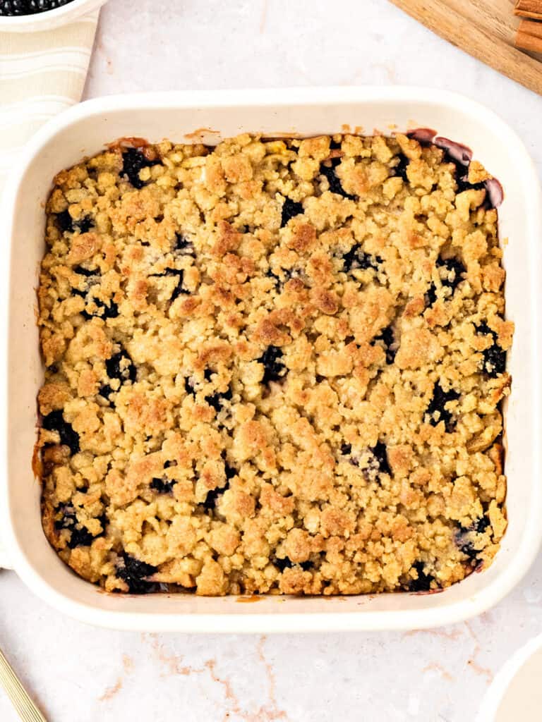 Golden apple berry crumble in a white dish.