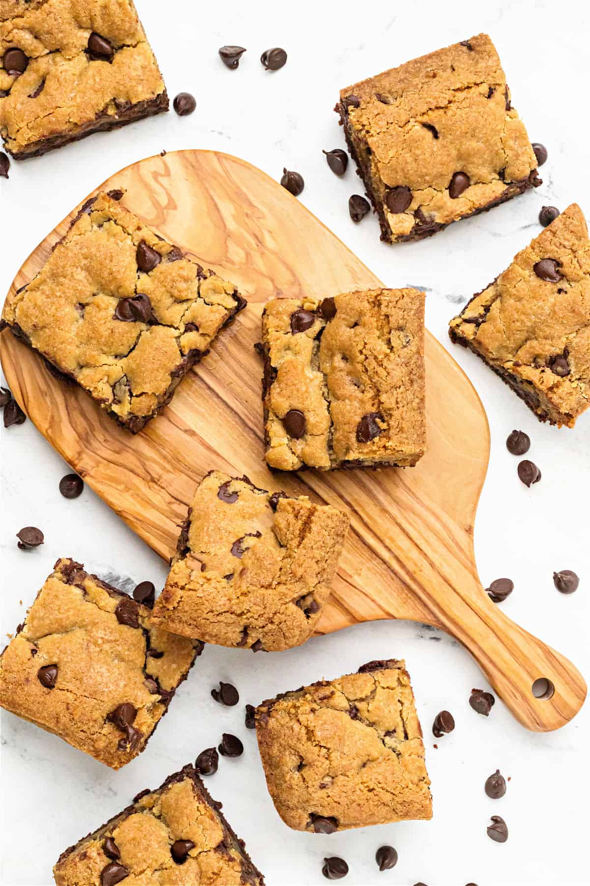 Wooden board with brookies squares. Loose chips, white background.