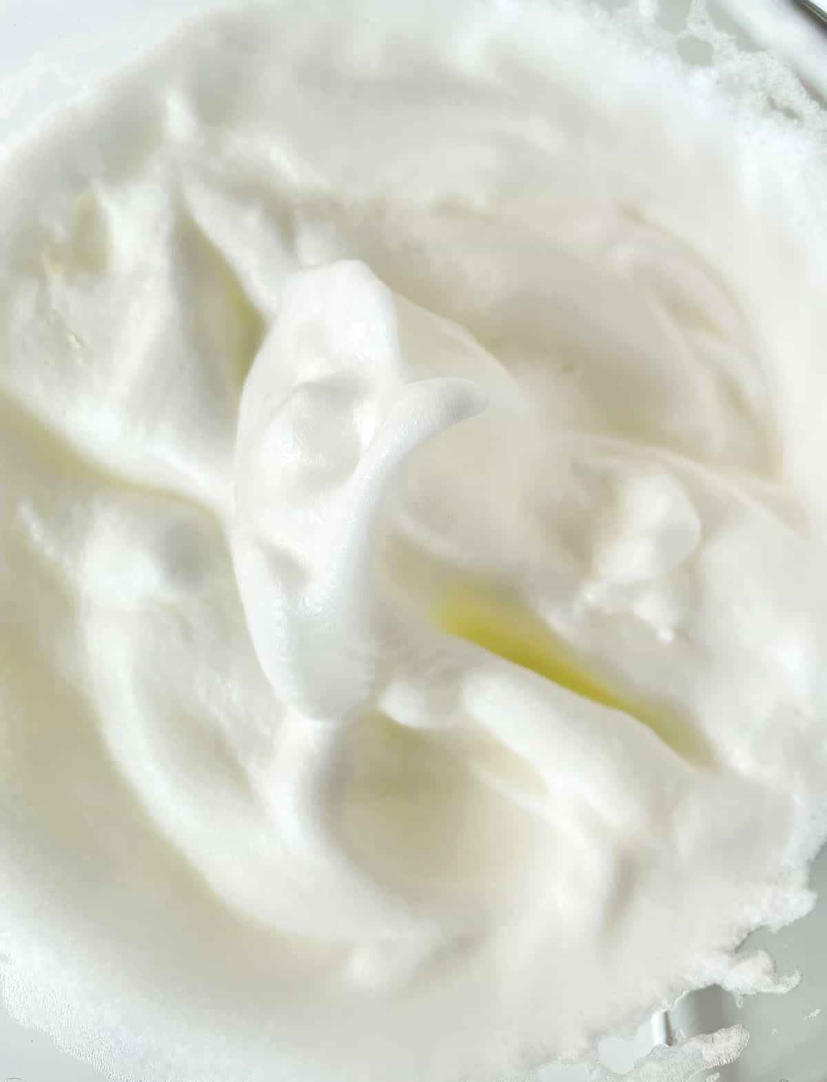 Egg whites beaten to firm peaks. Close up view.