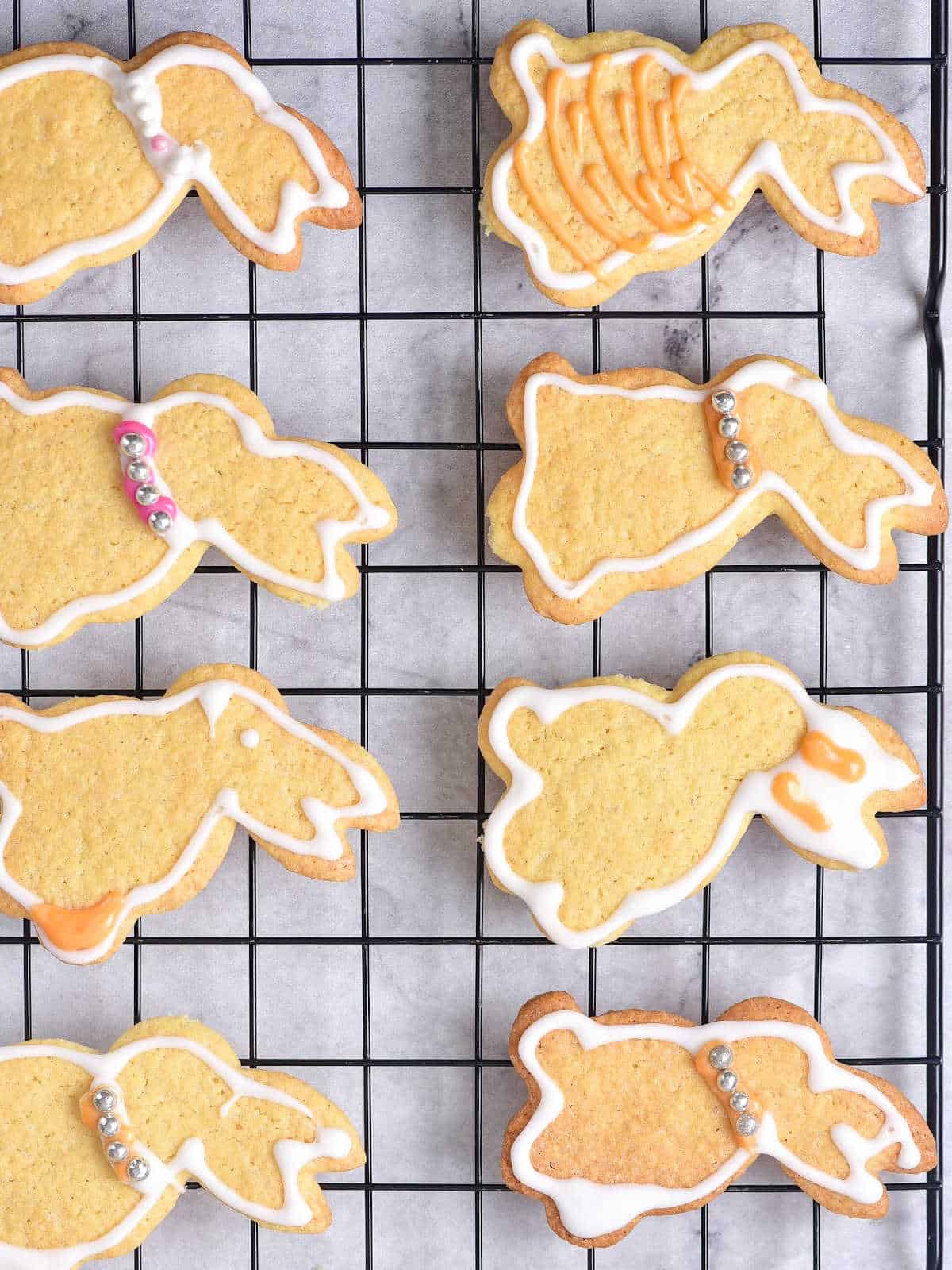 Two rows of iced bunny sugar cookies on a black wire rack with parchment paper underneath.